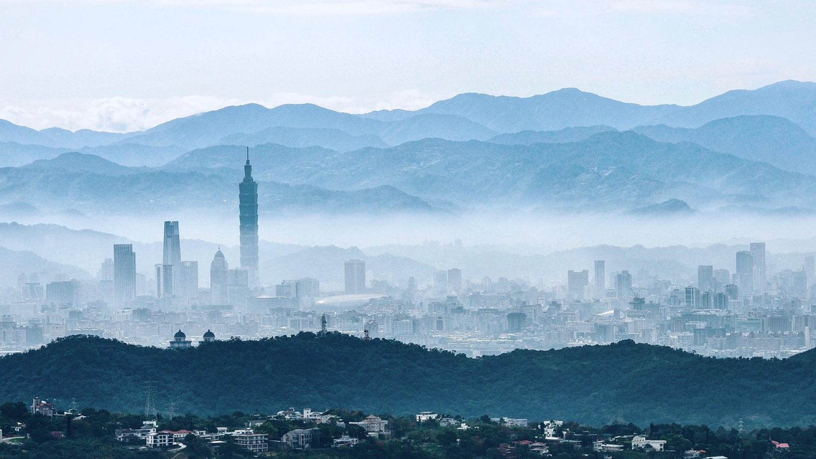 明日方舟 终末地 塔卫二废土荒野远景，锈红色天空下矗立着巨型工业设施与移动城市轮廓，氛围苍凉而宏大